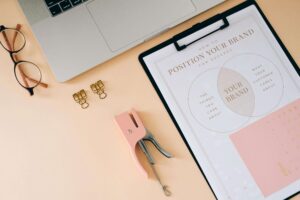 Desk split between digital tablet and printed flyer, showing integration of digital vs print